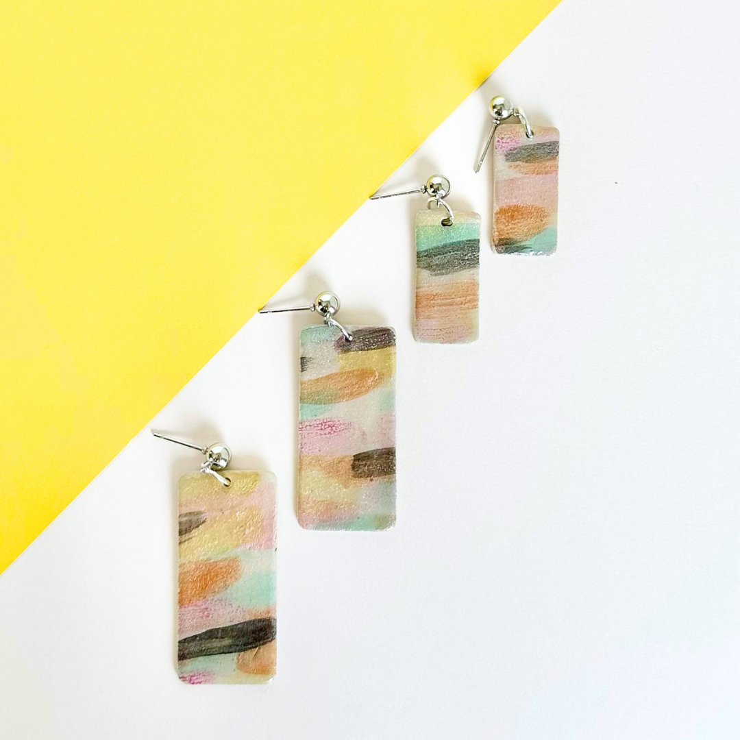 Colorful earrings on a yellow and white background